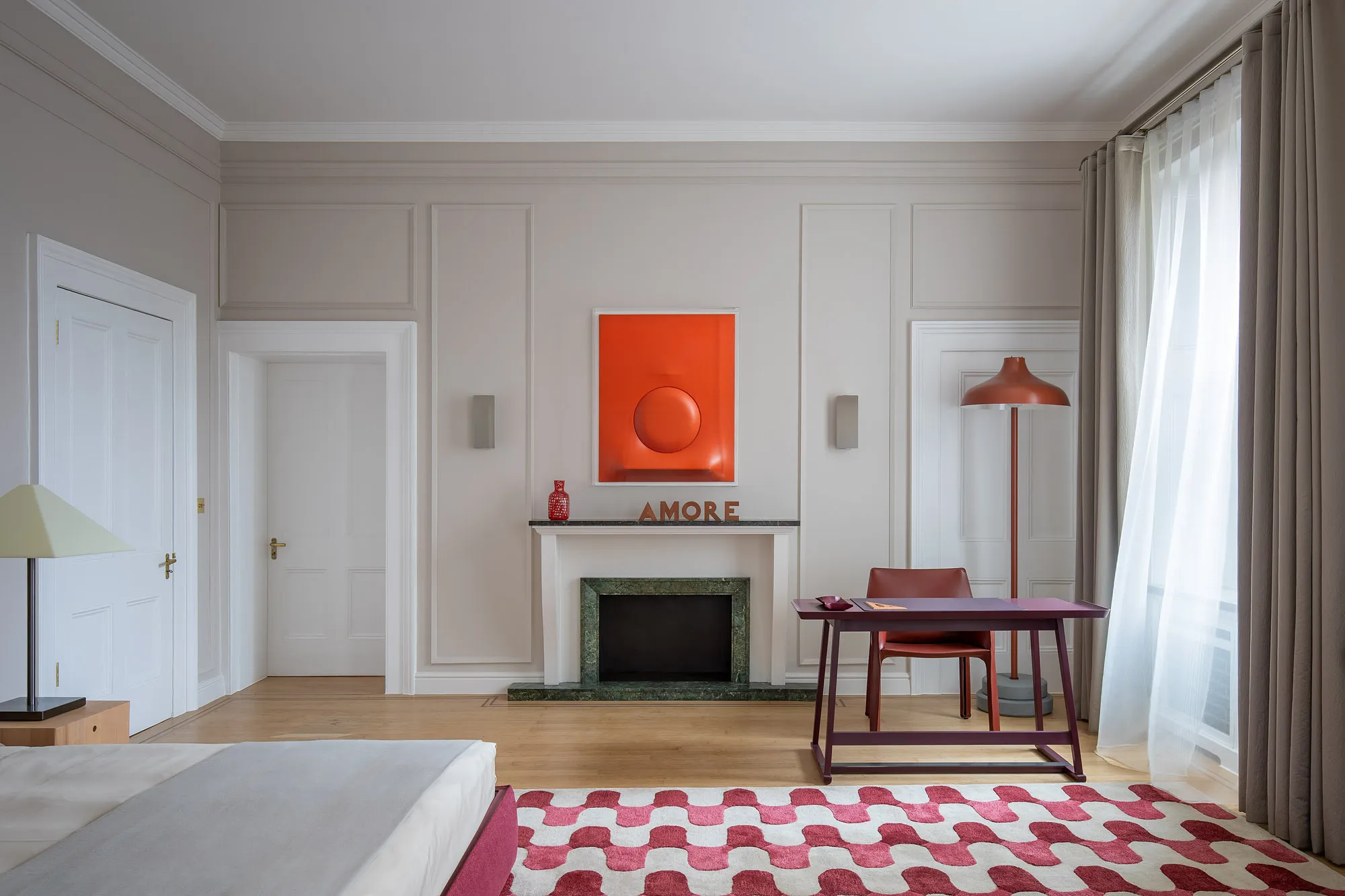 Italian ambassador’s London residence with a red artwork above the fireplace and a patterned rug
