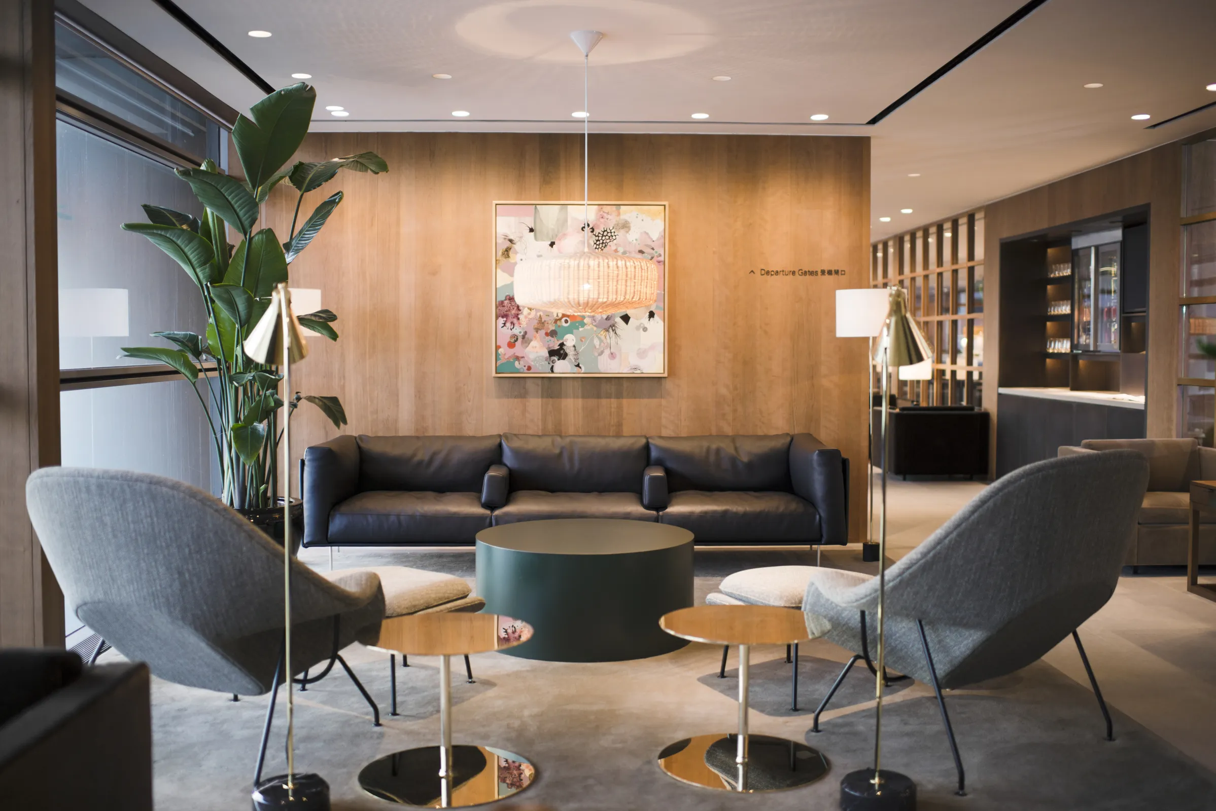 Cathay Pacific airport lounge with wood-panelled walls, grey seating and a low round table