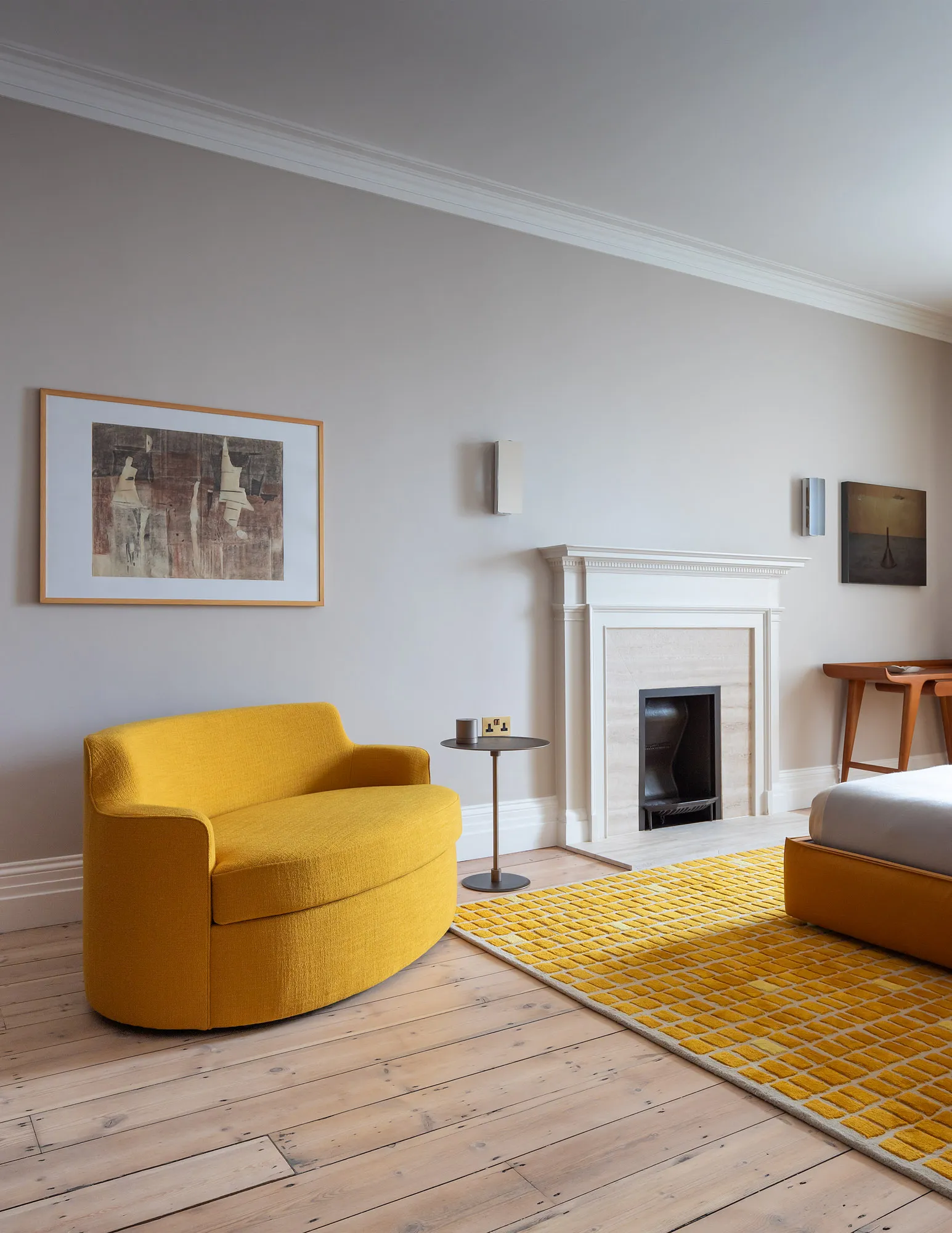 Yellow sofa beside a marble fireplace in the Italian ambassador’s London residence