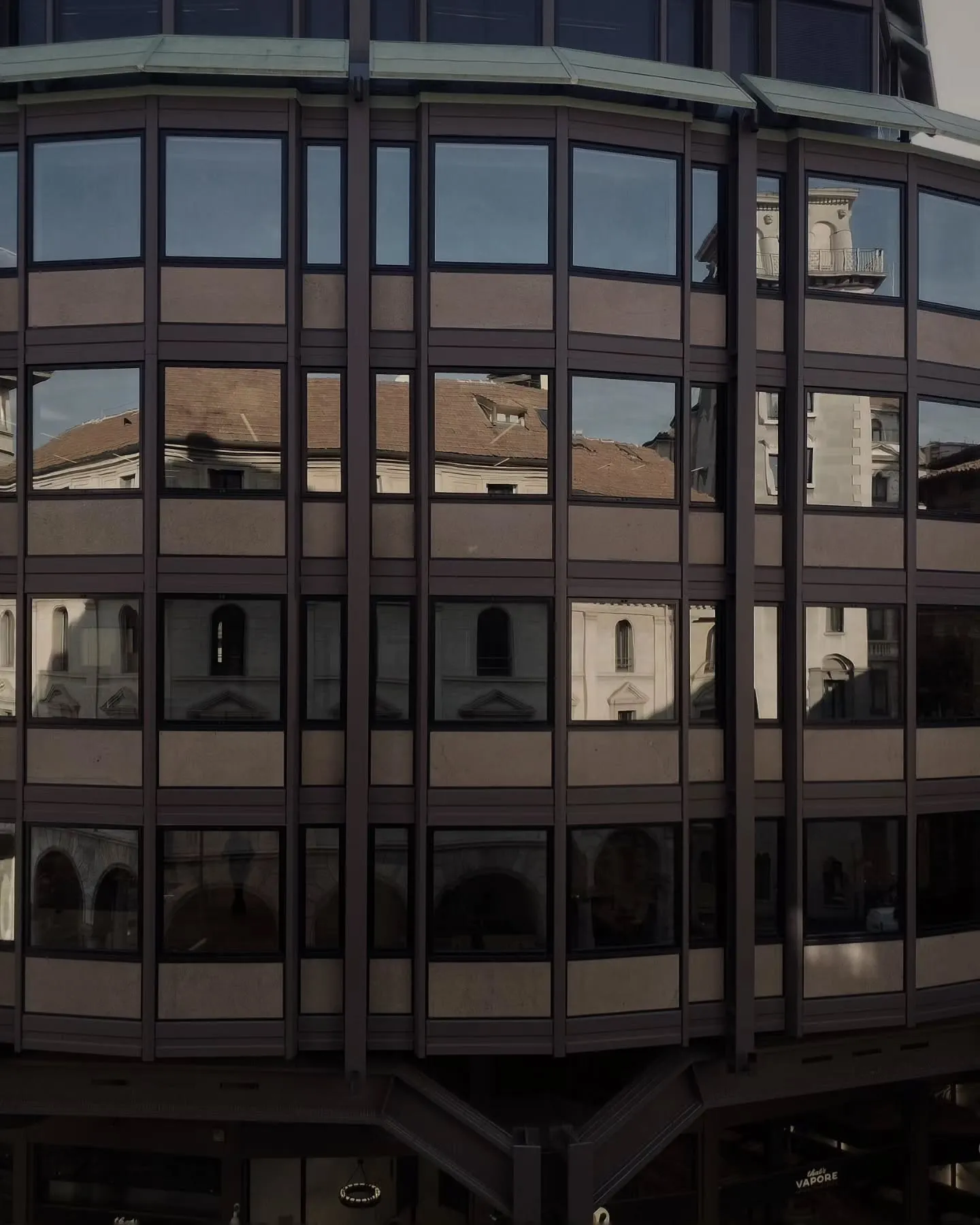 Curved glass facade of the Christofferson, Robb & Company office building in Milan