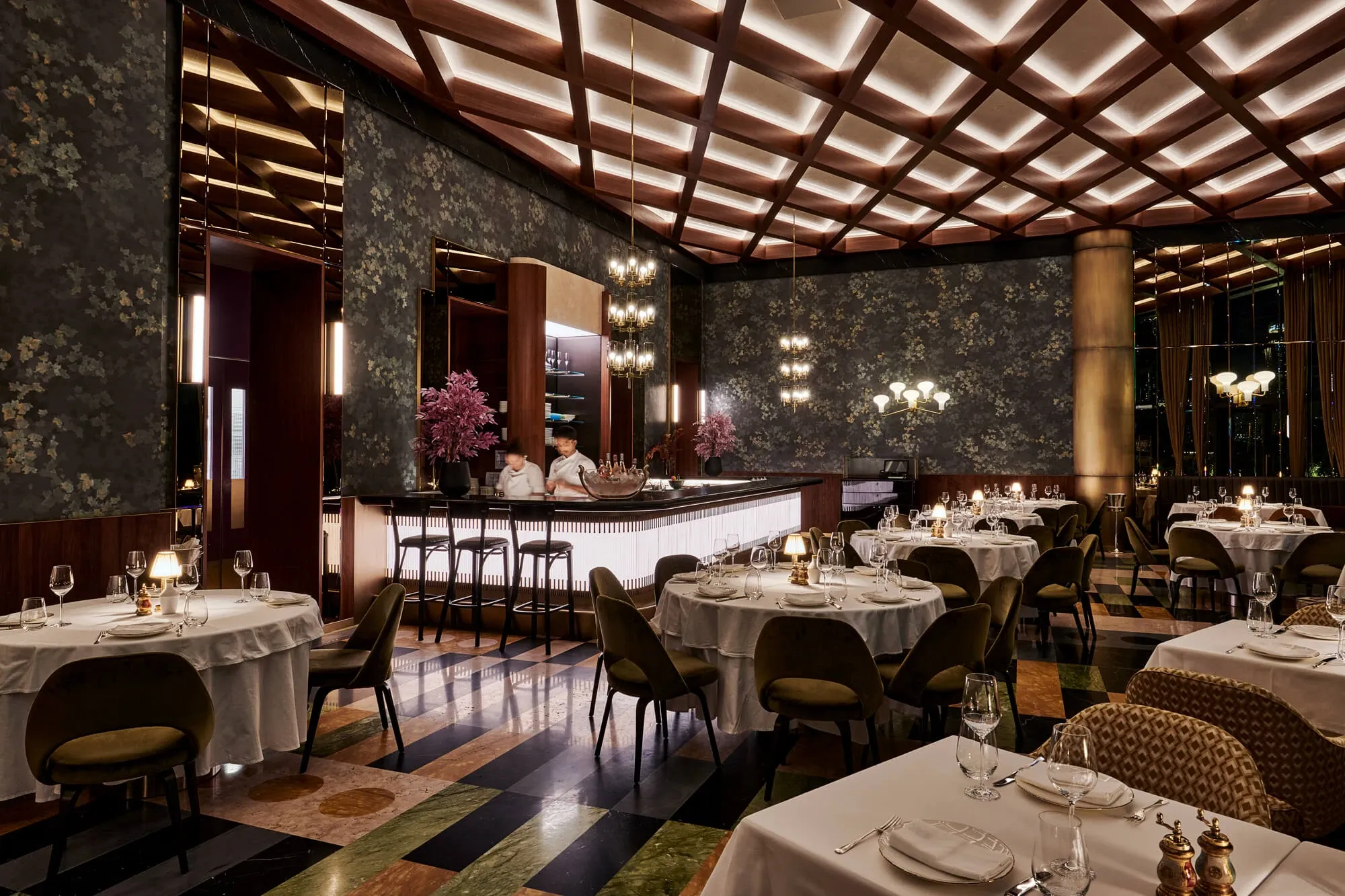 Dining room at The Arts Club Dubai with white table settings beneath a timber lattice ceiling