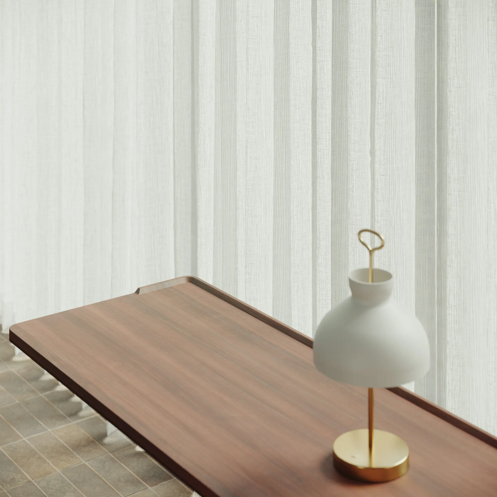 Close view of the Pupitre desk's satin walnut top with a table lamp
