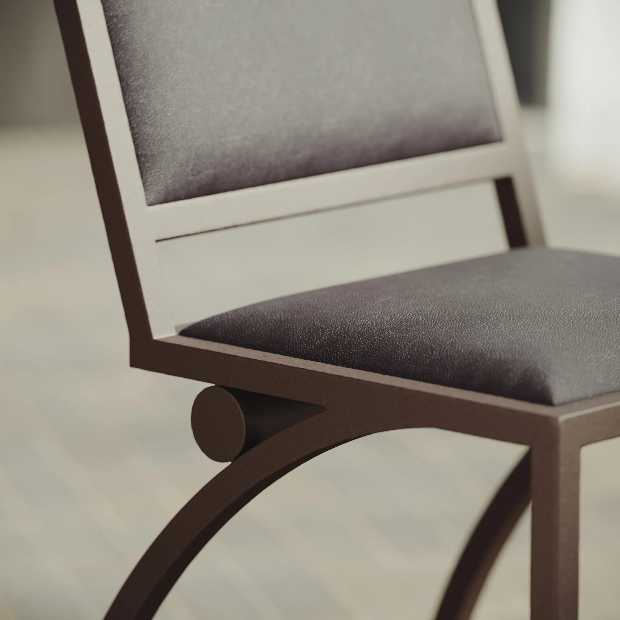 Detail of the Cylindre chair's leather seat, backrest and curved iron frame