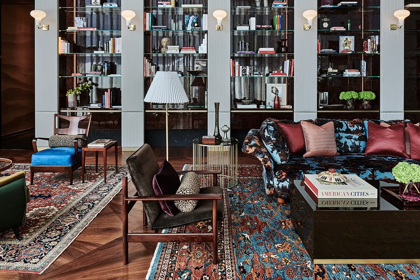 Library lounge at The Arts Club Dubai with sofas, patterned rugs and tall bookcases
