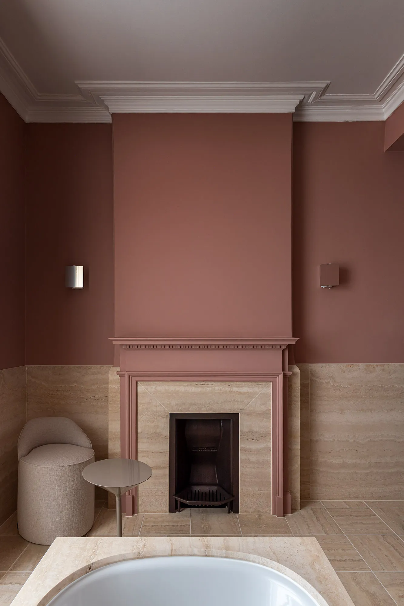 Pink room with a fireplace and low seating in the Italian ambassador’s residence