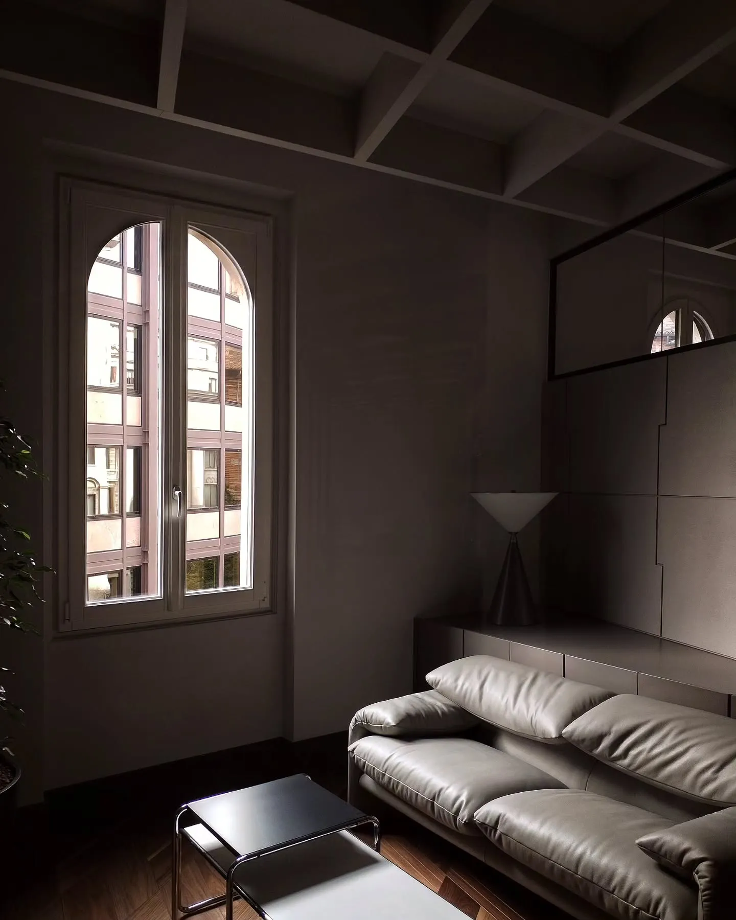 Leather sofa beside an arched window in a quiet office seating area