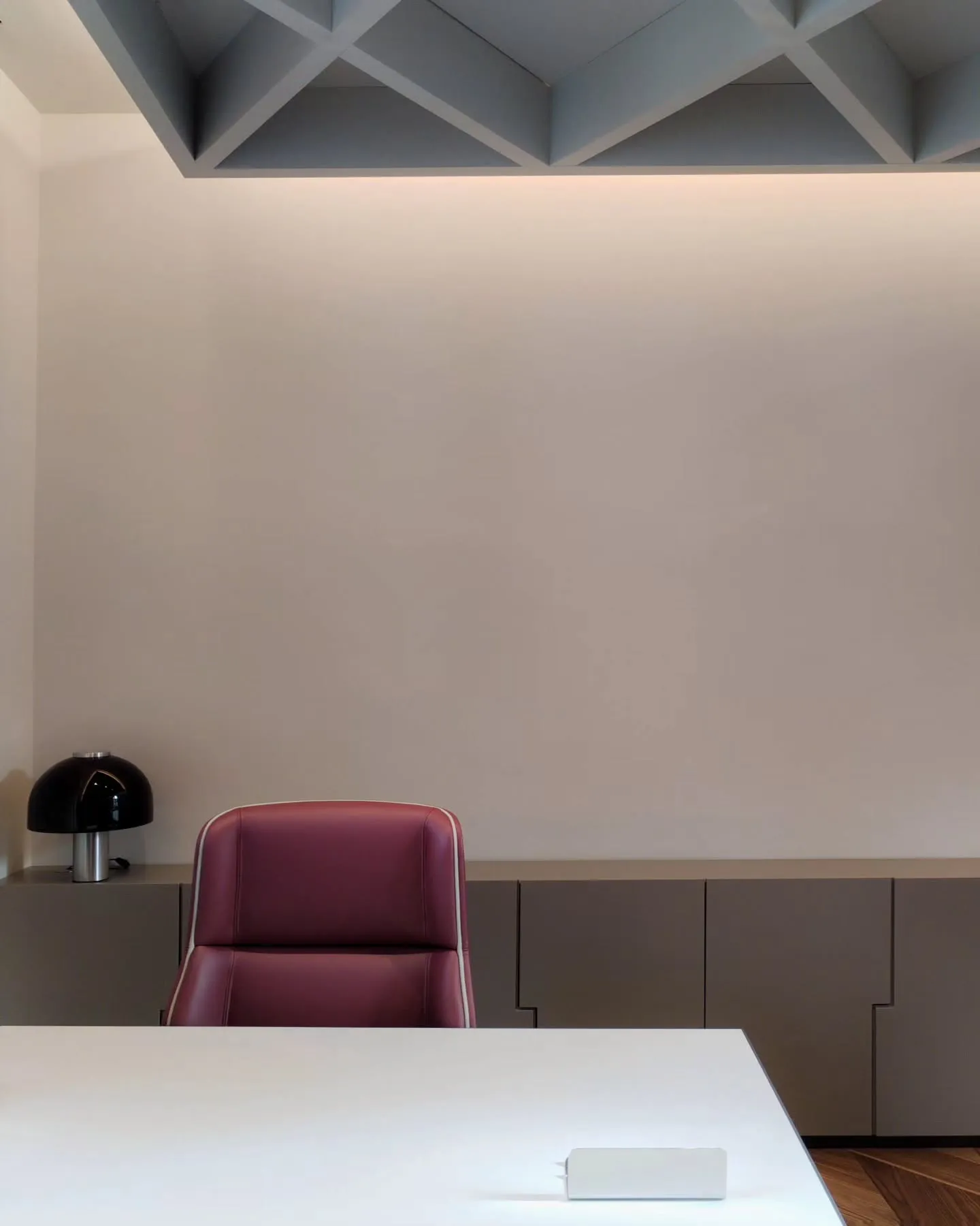 Workstation with a purple upholstered chair and a dark desk beneath the ceiling grid