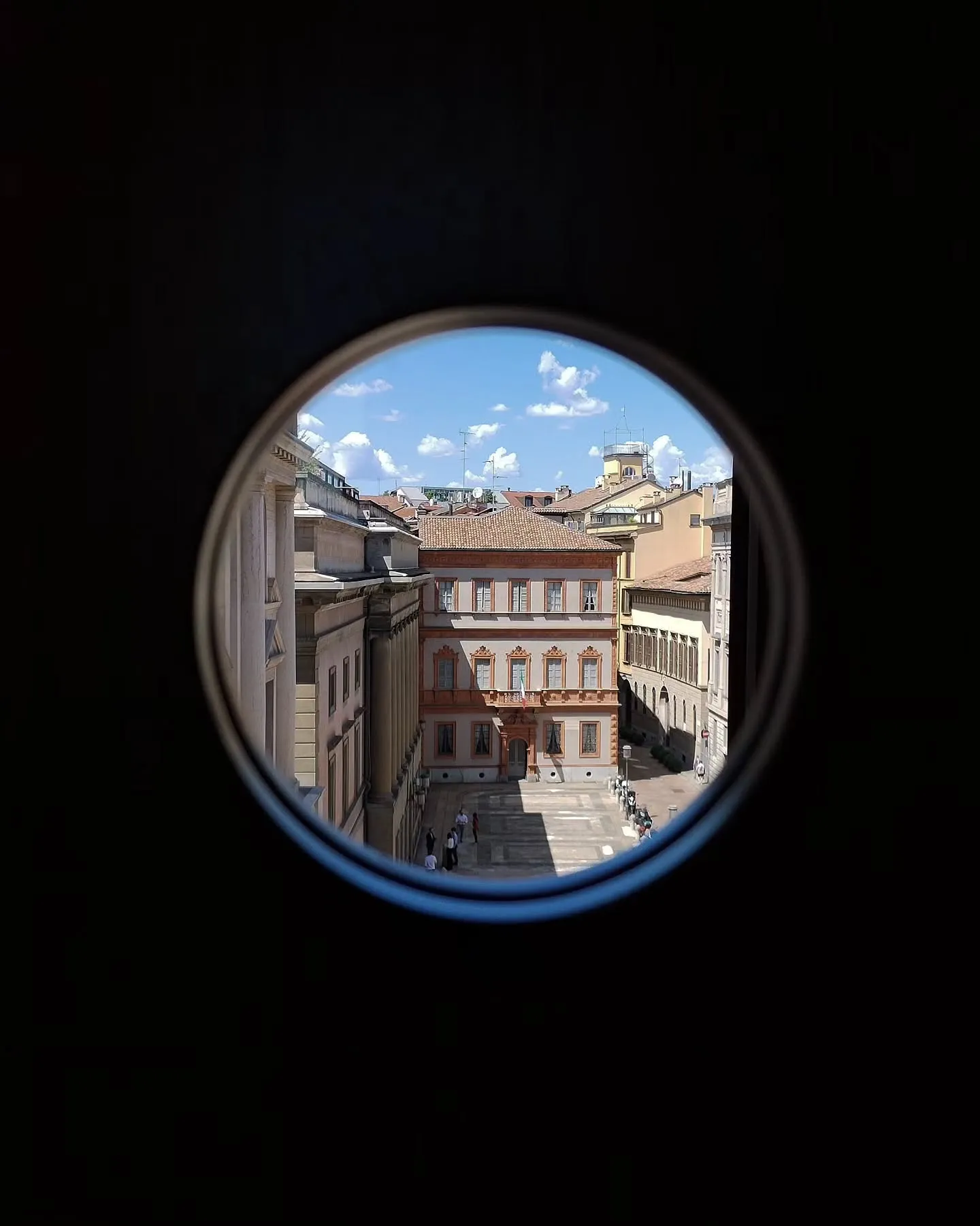 View of neighbouring Milan buildings through a circular office window