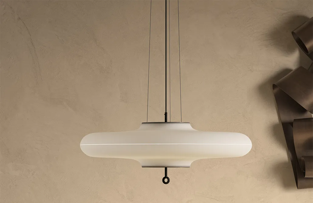 Close view of a polished brass TATO floor lamp against dark timber panelling